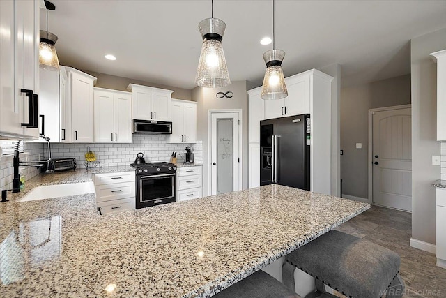 29696 Kevin Rd, New Baltimore, MI 48051 - kitchen with black fridge, range with gas cooktop, a peninsula, light stone counters, and recessed lighting