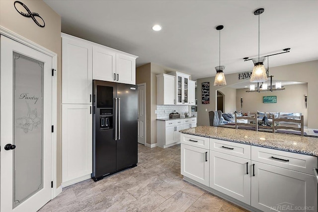 29696 Kevin Rd, New Baltimore, MI 48051 - kitchen with high quality fridge, white cabinets, light stone countertops, backsplash, and hanging light fixtures
