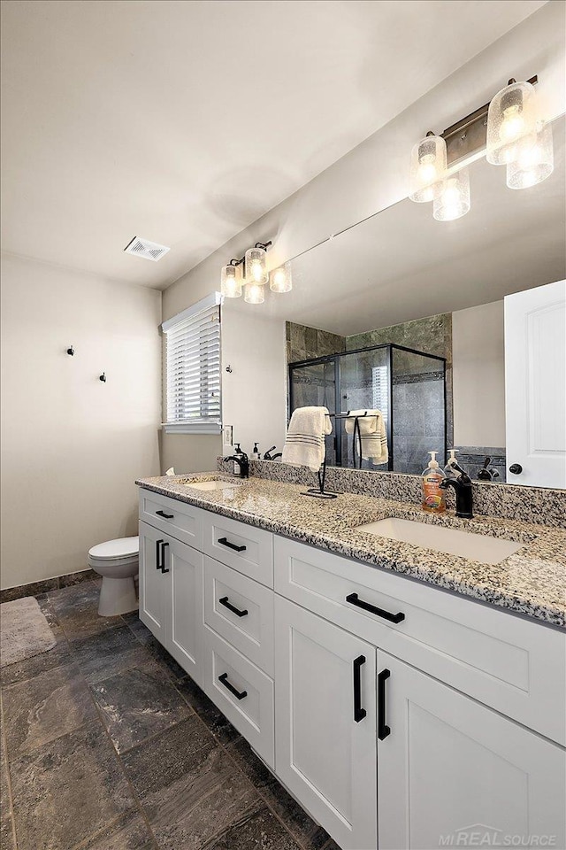 29696 Kevin Rd, New Baltimore, MI 48051 - bathroom with double vanity, a stall shower, stone finish flooring, toilet, and baseboards