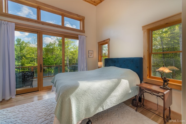 509 Red Rd, Michigamme, MI 49861 - bedroom featuring access to exterior, wood finished floors, and a towering ceiling