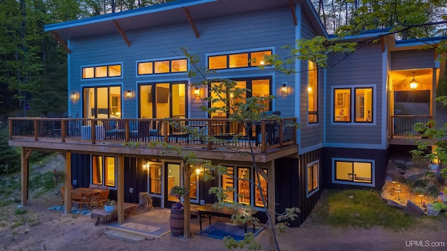 509 Red Rd, Michigamme, MI 49861 - rear view of house featuring board and batten siding, a patio area, and a wooden deck