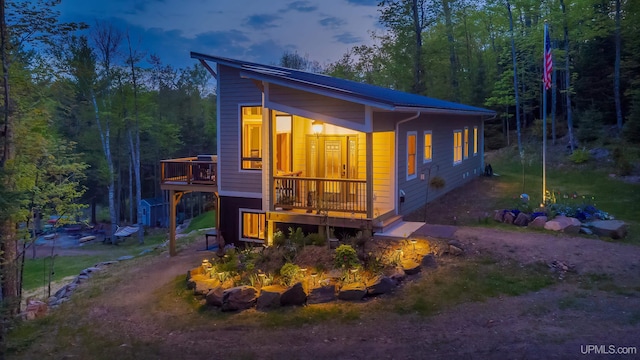 509 Red Rd, Michigamme, MI 49861 - view of front of house with a deck, driveway, and a wooded view