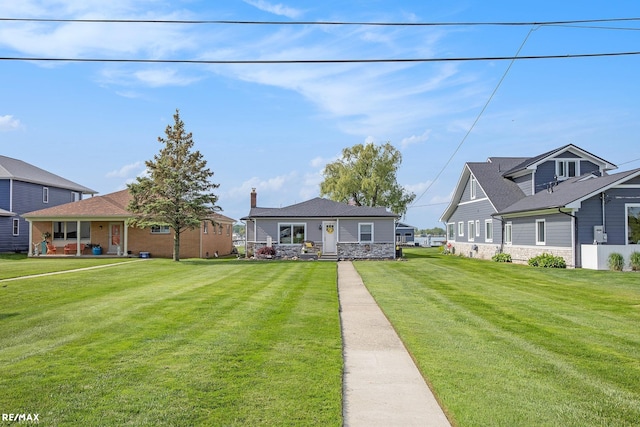 5227 Pointe Tremble Rd, Algonac, MI 48001 - view of front of house featuring a front lawn, a chimney, and stone siding