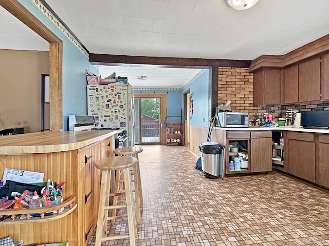 W5624 County Road 388th Rd, Hermansville, MI 49847 - kitchen featuring stainless steel appliances, light countertops, wainscoting, wooden walls, and brown cabinets