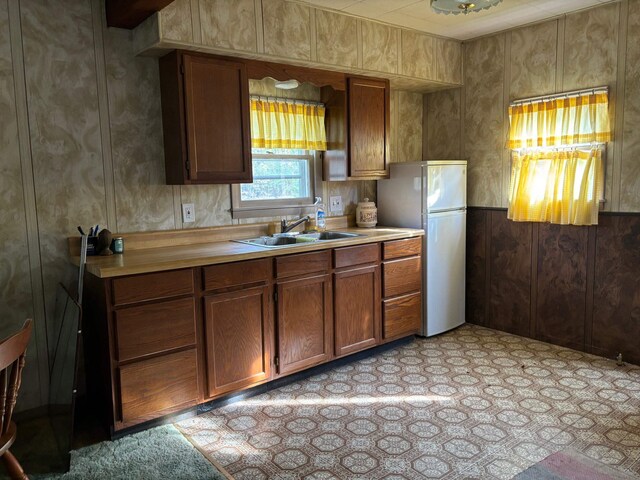 5316 Birchwood Ave, Gladwin, MI 48624 - kitchen with freestanding refrigerator, a sink, light countertops, and brown cabinets