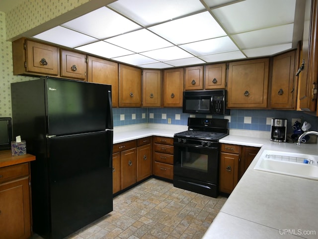 26514 Hendrickson Rd, Calumet, MI 49913 - kitchen featuring black appliances, a sink, wallpapered walls, light countertops, and tasteful backsplash