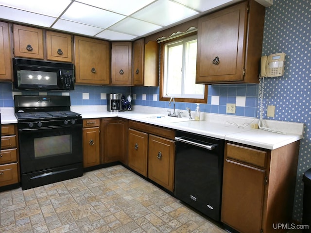 26514 Hendrickson Rd, Calumet, MI 49913 - kitchen featuring black appliances, a sink, light countertops, decorative backsplash, and wallpapered walls