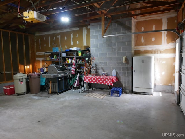 26514 Hendrickson Rd, Calumet, MI 49913 - garage featuring a garage door opener, concrete block wall, and a workshop area