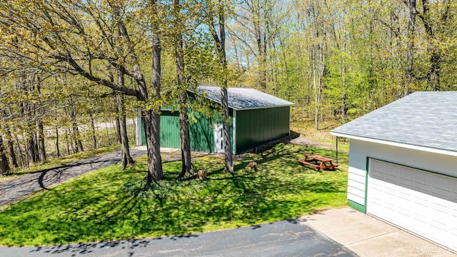26514 Hendrickson Rd, Calumet, MI 49913 - view of grassy yard featuring an outdoor structure and a garage