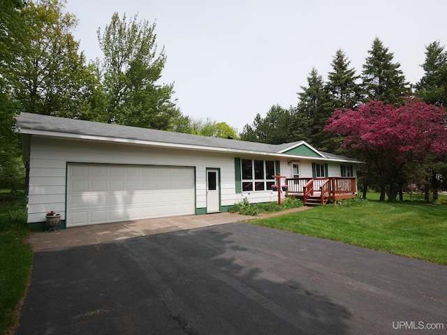 26514 Hendrickson Rd, Calumet, MI 49913 - single story home featuring asphalt driveway, a front lawn, and an attached garage