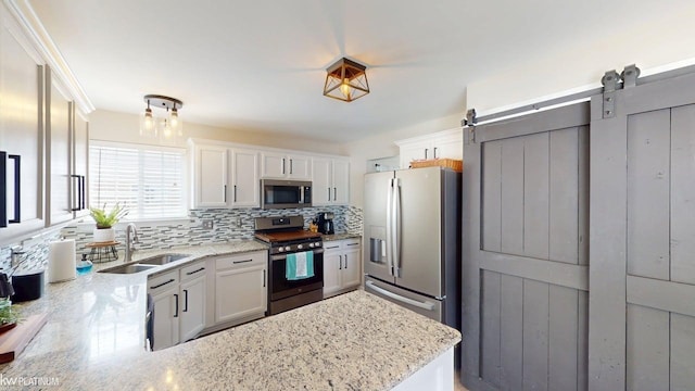 35532 Harrison St, New Baltimore, MI 48047 - kitchen featuring appliances with stainless steel finishes, a sink, decorative backsplash, white cabinetry, and light stone countertops
