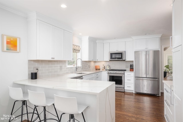 766 Lakeland St, Grosse Pointe, MI 48230 - kitchen with appliances with stainless steel finishes, a sink, a peninsula, white cabinetry, and tasteful backsplash