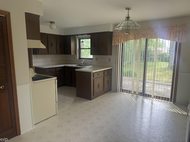 26167 Fairfield Ave, Warren, MI 48089 - kitchen featuring light countertops, decorative backsplash, dark brown cabinetry, and washer / dryer