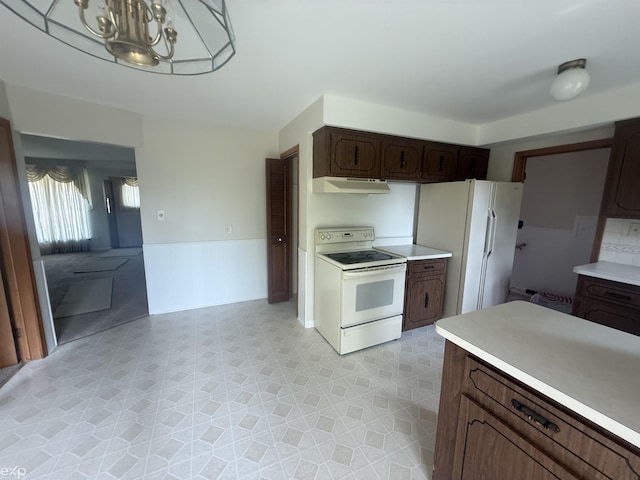 26167 Fairfield Ave, Warren, MI 48089 - kitchen featuring white appliances, under cabinet range hood, light floors, light countertops, and a wainscoted wall
