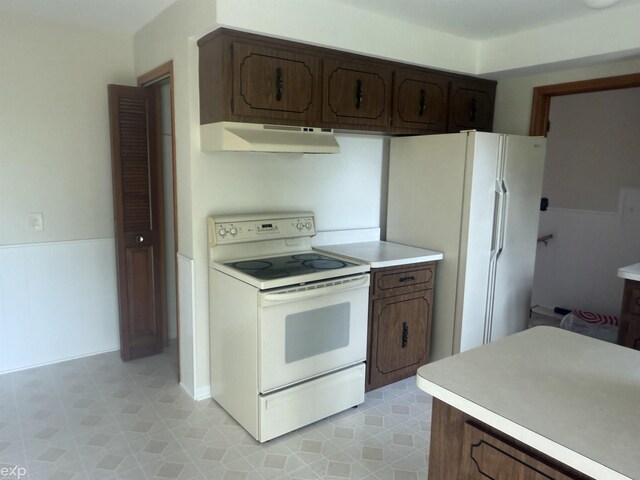 26167 Fairfield Ave, Warren, MI 48089 - kitchen with white appliances, under cabinet range hood, light countertops, and dark brown cabinets