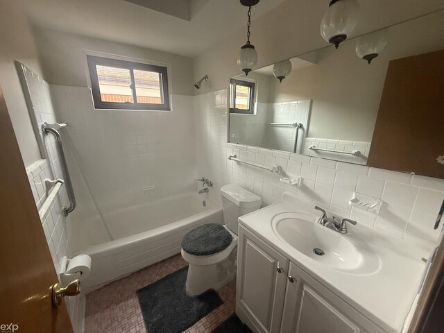 26167 Fairfield Ave, Warren, MI 48089 - full bathroom featuring shower / bathtub combination, toilet, vanity, tile walls, and tile patterned floors
