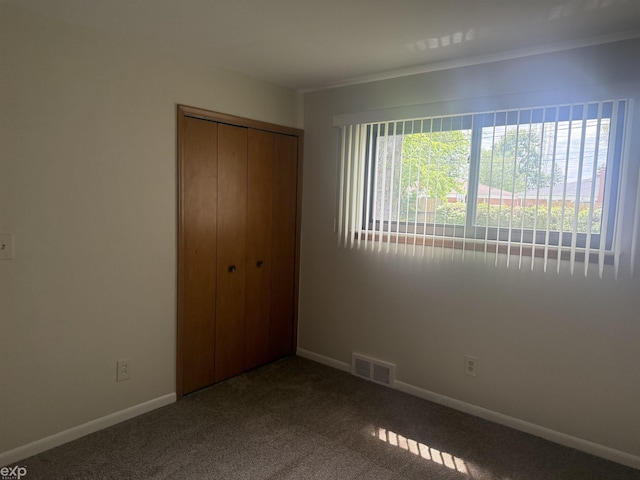 26167 Fairfield Ave, Warren, MI 48089 - unfurnished bedroom with a closet, dark carpet, baseboards, and crown molding