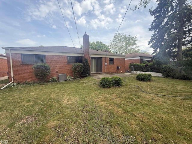26167 Fairfield Ave, Warren, MI 48089 - rear view of house with brick siding, a chimney, central AC, and a patio area