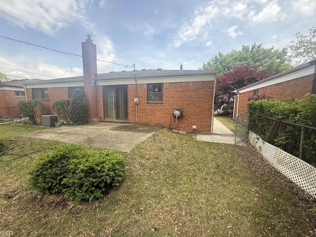 26167 Fairfield Ave, Warren, MI 48089 - back of house featuring a patio, brick siding, central air condition unit, and a chimney