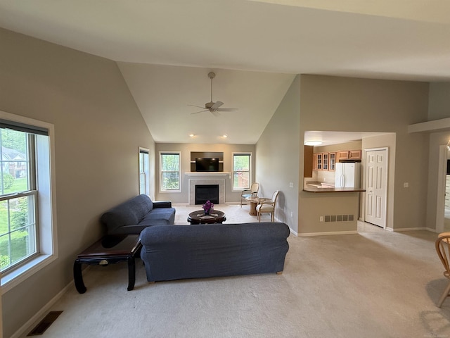 119 Pondview Ct, Brighton, MI 48116 - living area featuring a tile fireplace, light colored carpet, plenty of natural light, and high vaulted ceiling
