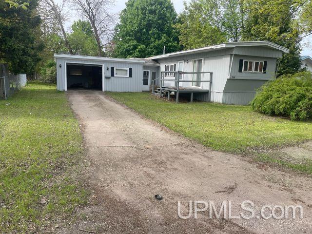729 Breitung Ave, Kingsford, MI 49801 - manufactured / mobile home with an attached garage, asphalt driveway, and a front yard