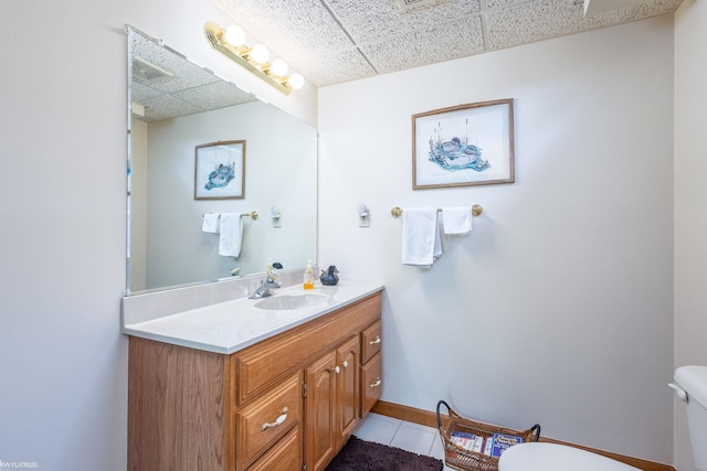 518 Lexington Dr, Rochester Hills, MI 48307 - half bathroom featuring toilet, tile patterned flooring, vanity, a paneled ceiling, and baseboards