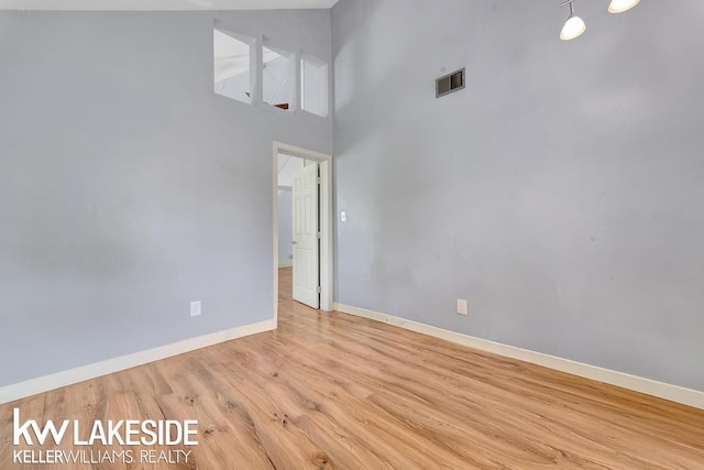 7184 Baker Rd, Worth Twp, MI 48450 - empty room featuring baseboards, light wood-type flooring, and a high ceiling