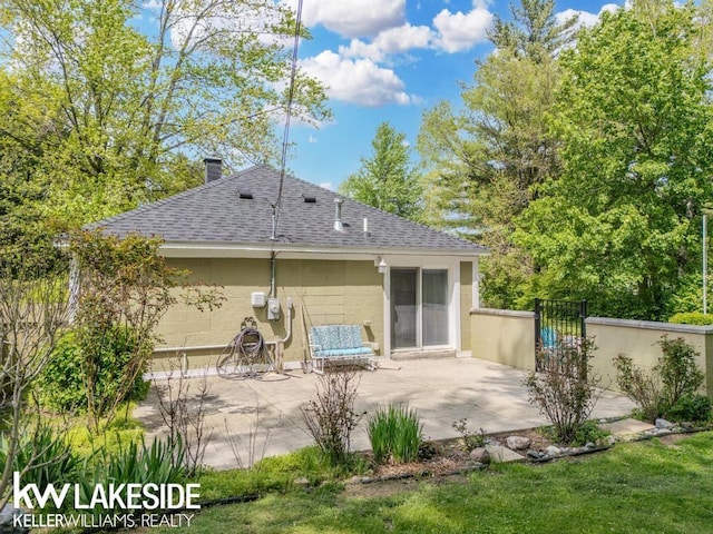 7184 Baker Rd, Worth Twp, MI 48450 - back of house with roof with shingles, a patio, concrete block siding, and a chimney