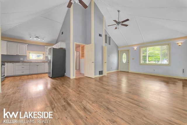 7184 Baker Rd, Worth Twp, MI 48450 - unfurnished living room featuring a ceiling fan, high vaulted ceiling, a sink, and light wood finished floors