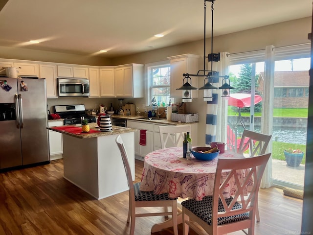727 Townsend Dr, Algonac, MI 48001 - kitchen featuring appliances with stainless steel finishes, a kitchen island, wood finished floors, white cabinetry, and a sink