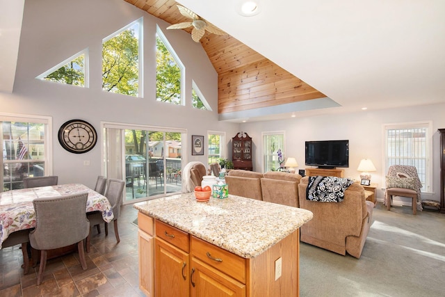8735 Blackberry Ln, Port Austin, MI 48467 - kitchen featuring a kitchen island, recessed lighting, light stone countertops, open floor plan, and high vaulted ceiling