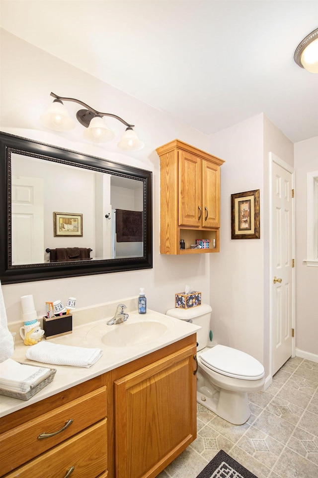 8735 Blackberry Ln, Port Austin, MI 48467 - bathroom featuring vanity, toilet, and baseboards