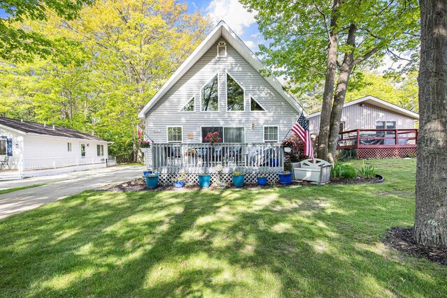 8735 Blackberry Ln, Port Austin, MI 48467 - rear view of house featuring a wooden deck and a lawn