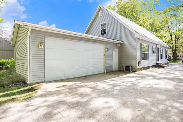 8735 Blackberry Ln, Port Austin, MI 48467 - view of property exterior with cooling unit, concrete driveway, and a garage