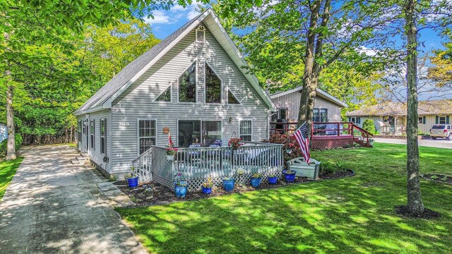 8735 Blackberry Ln, Port Austin, MI 48467 - rear view of house featuring a deck and a lawn