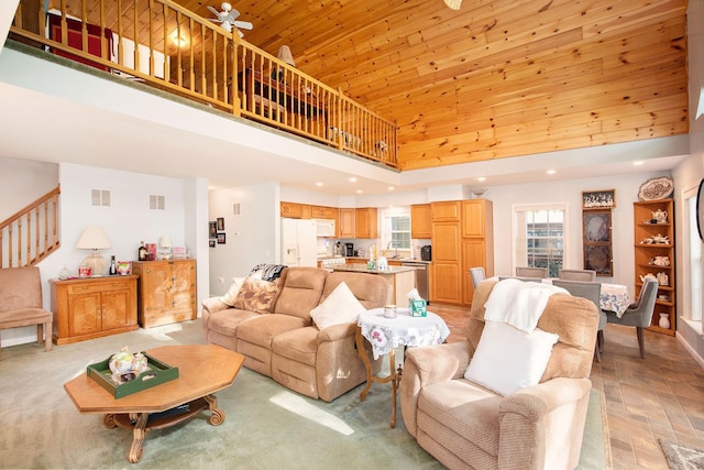 8735 Blackberry Ln, Port Austin, MI 48467 - living area featuring a high ceiling, stairs, wooden ceiling, a ceiling fan, and baseboards