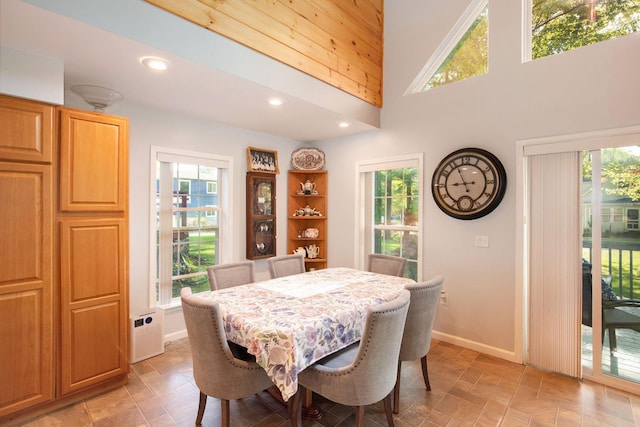 8735 Blackberry Ln, Port Austin, MI 48467 - dining space featuring baseboards, recessed lighting, a high ceiling, and light stone finish flooring