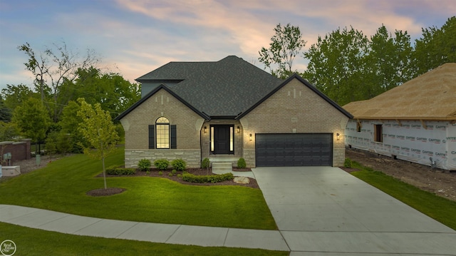 16612 Via Villagio Dr, Macomb, MI 48042 - view of front facade with driveway, brick siding, a garage, a yard, and roof with shingles