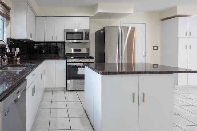 5311 Cambourne Pl, West Bloomfield, MI 48322 - kitchen featuring stainless steel appliances, a sink, dark stone counters, and white cabinetry