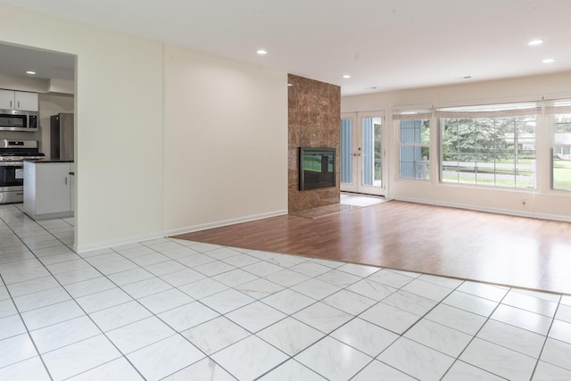 5311 Cambourne Pl, West Bloomfield, MI 48322 - unfurnished living room with recessed lighting, light wood-style floors, a tiled fireplace, and baseboards