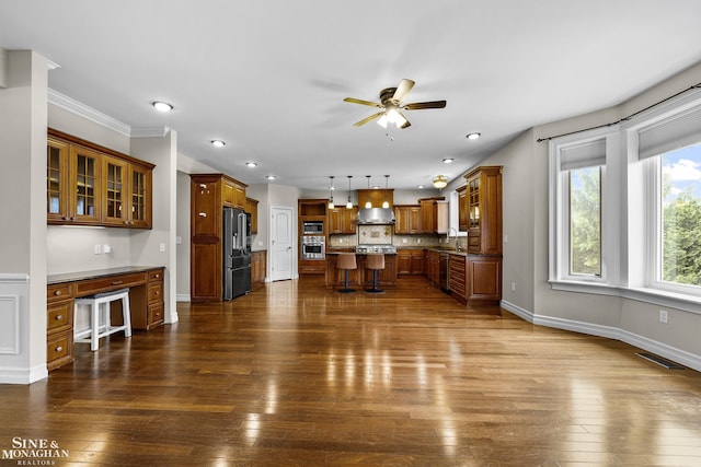 26898 Alderman Ct, Harrison Twp, MI 48045 - kitchen featuring appliances with stainless steel finishes, a sink, brown cabinetry, a breakfast bar area, and a ceiling fan