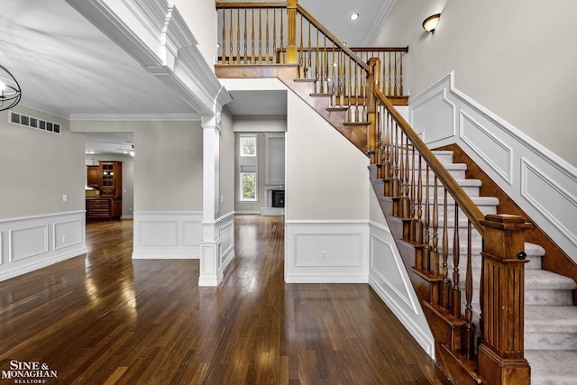 26898 Alderman Ct, Harrison Twp, MI 48045 - stairway with decorative columns, a decorative wall, crown molding, hardwood / wood-style floors, and a wainscoted wall