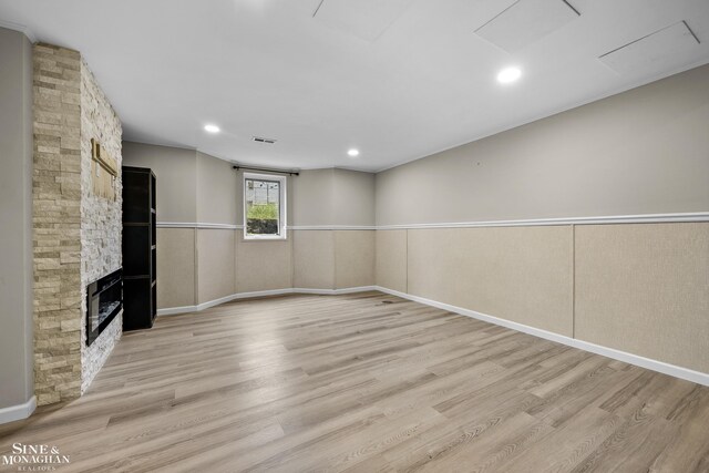 26898 Alderman Ct, Harrison Twp, MI 48045 - unfurnished living room with light wood-style floors, a fireplace, baseboards, and wainscoting