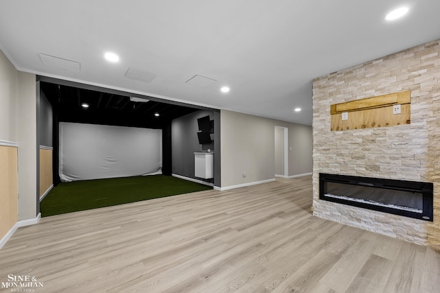 26898 Alderman Ct, Harrison Twp, MI 48045 - unfurnished living room featuring golf simulator, wood finished floors, a stone fireplace, baseboards, and recessed lighting