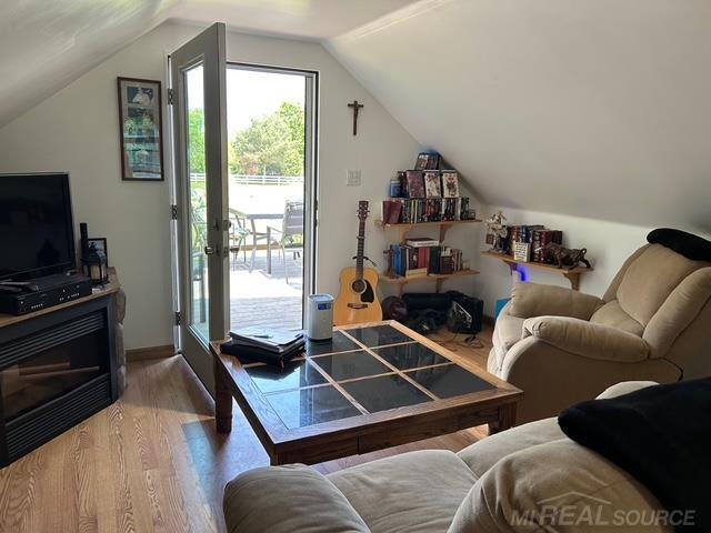 7696 Varty Ct, Lexington, MI 48450 - living area with wood finished floors and vaulted ceiling