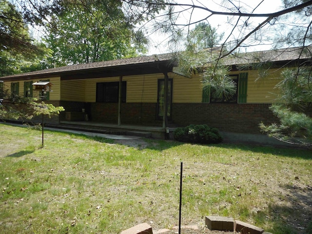 2575 W Huron Rd, Standish, MI 48658 - rear view of house with a lawn and brick siding
