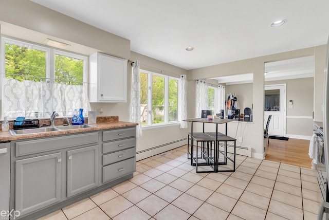 3365 Hickory Ln, Port Huron, MI 48060 - kitchen with a baseboard heating unit, a sink, light tile patterned flooring, recessed lighting, and light countertops