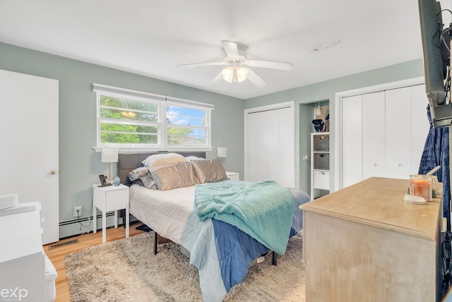 3365 Hickory Ln, Port Huron, MI 48060 - bedroom featuring multiple closets, baseboard heating, light wood-style floors, and ceiling fan