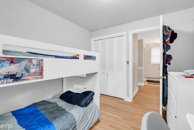 3365 Hickory Ln, Port Huron, MI 48060 - bedroom featuring baseboard heating, light wood-style flooring, a closet, and baseboards