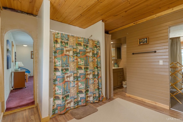 4427 Tip Up Trl, Eagle River, WI 54521 - bathroom featuring wood finished floors, a shower with shower curtain, vanity, wooden walls, and wooden ceiling